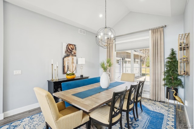 dining area with wood finished floors, baseboards, visible vents, vaulted ceiling, and a notable chandelier