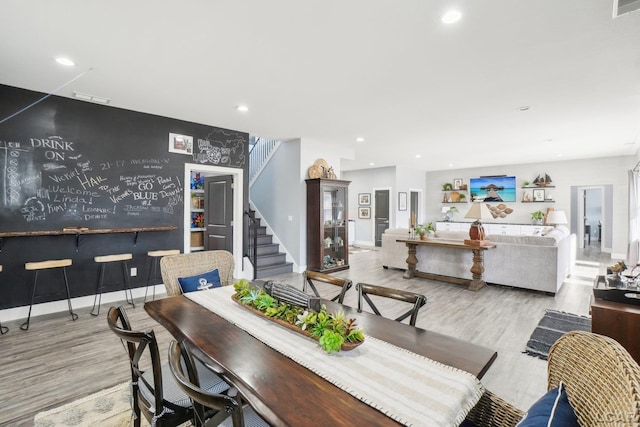 dining space with visible vents, baseboards, stairway, recessed lighting, and wood finished floors