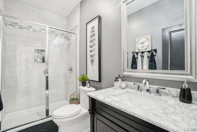 bathroom with a stall shower, toilet, and vanity