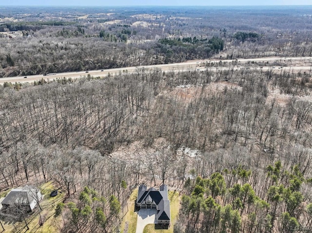 birds eye view of property featuring a forest view