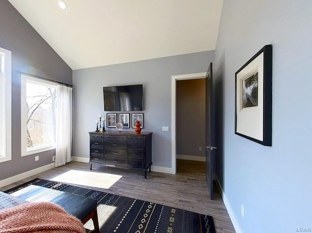 bedroom featuring lofted ceiling, wood finished floors, and baseboards