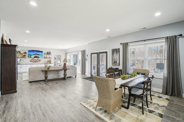 dining area with light wood finished floors, visible vents, recessed lighting, and french doors