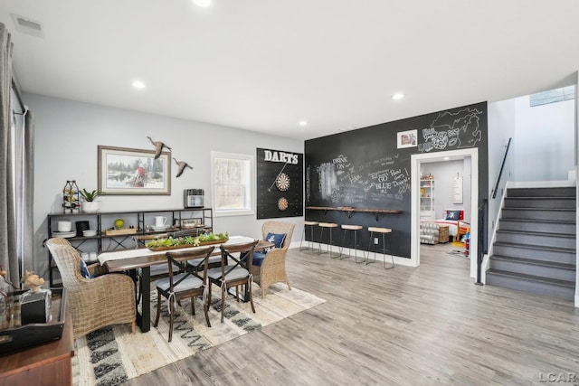 dining area with wood finished floors, visible vents, baseboards, recessed lighting, and stairs