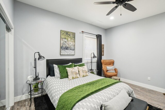 bedroom featuring a ceiling fan, recessed lighting, wood finished floors, and baseboards