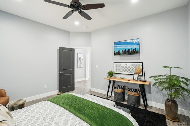 bedroom featuring baseboards, wood finished floors, and a ceiling fan