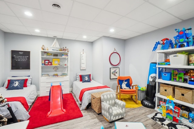 bedroom with visible vents, recessed lighting, a paneled ceiling, and wood finished floors