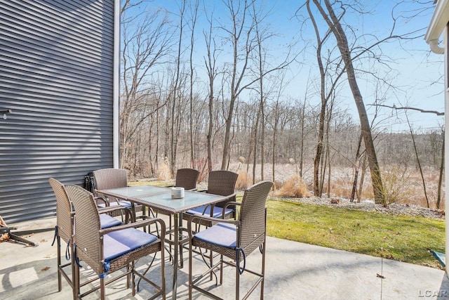 view of patio / terrace with outdoor dining area and a forest view