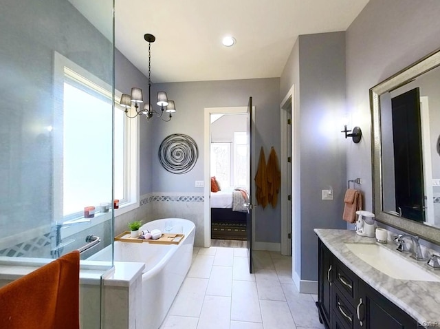 ensuite bathroom with tile patterned floors, a notable chandelier, ensuite bathroom, a washtub, and vanity