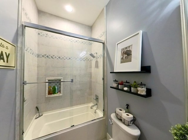 full bath with toilet and shower / bath combination with glass door