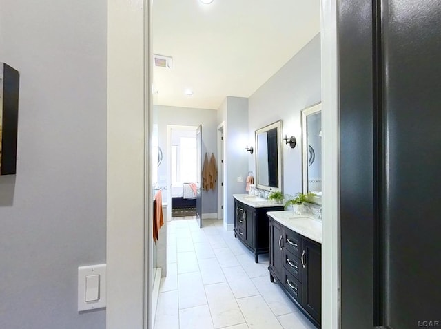 full bath with visible vents, baseboards, two vanities, tile patterned flooring, and ensuite bathroom