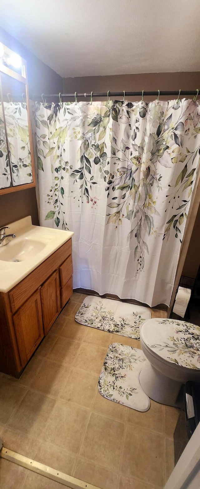 bathroom with tile patterned floors, toilet, a shower with shower curtain, and vanity