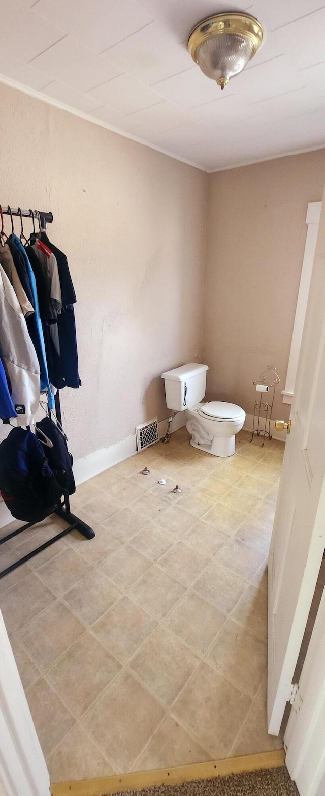 bathroom with visible vents, toilet, and baseboards