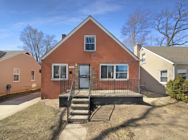 view of front of house with brick siding, central air condition unit, and a chimney