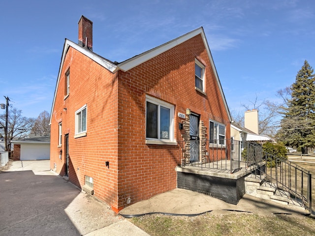 view of front of property featuring brick siding and a chimney