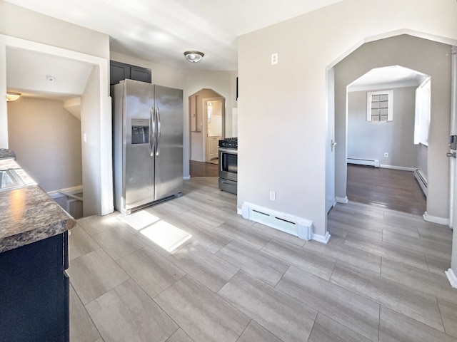 interior space featuring stove, baseboard heating, arched walkways, and stainless steel fridge with ice dispenser