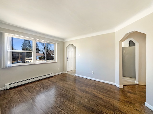 unfurnished room with a baseboard heating unit, arched walkways, baseboards, and wood finished floors