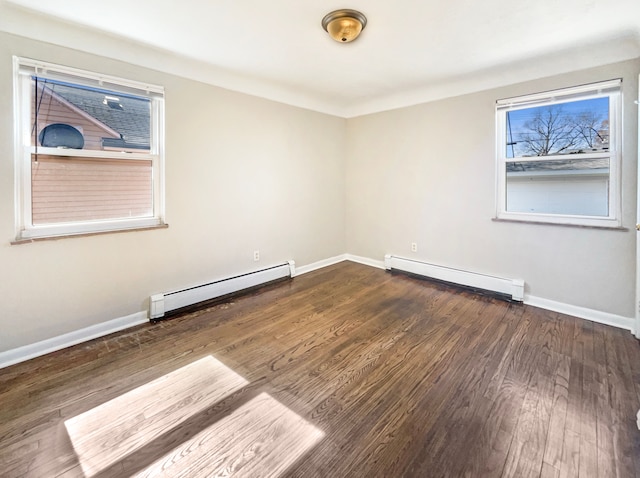 spare room with a baseboard radiator, baseboards, baseboard heating, and wood finished floors