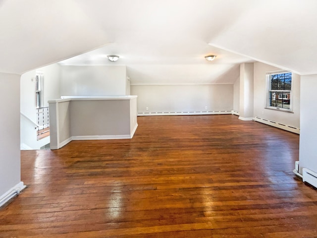 additional living space featuring baseboards, baseboard heating, hardwood / wood-style floors, and vaulted ceiling