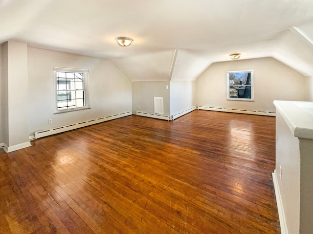 additional living space with hardwood / wood-style flooring, lofted ceiling, and a baseboard radiator