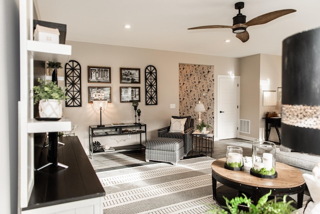 living area with wood finished floors, a ceiling fan, visible vents, baseboards, and recessed lighting