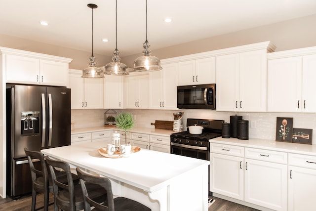 kitchen featuring decorative backsplash, appliances with stainless steel finishes, a center island, and white cabinetry