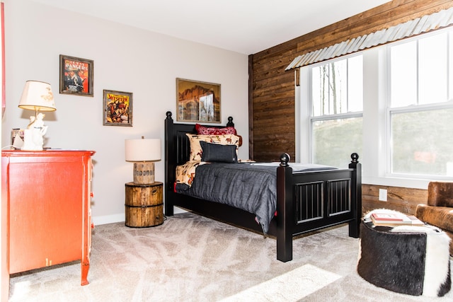 bedroom featuring light carpet and wooden walls