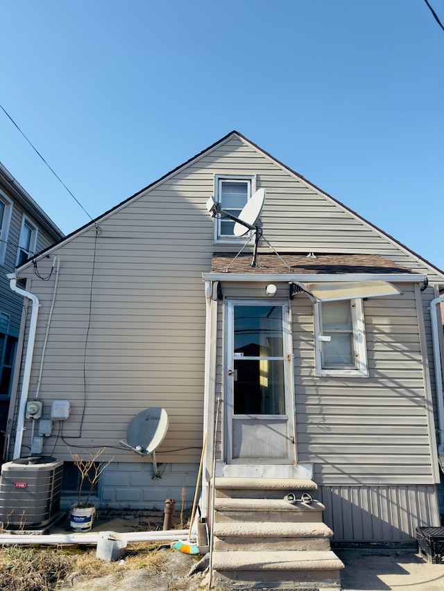 rear view of house with central AC and entry steps