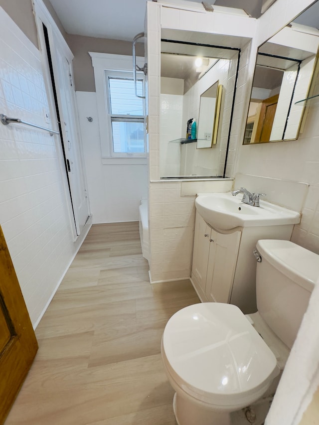 full bath with vanity, toilet, tile walls, and wood finished floors