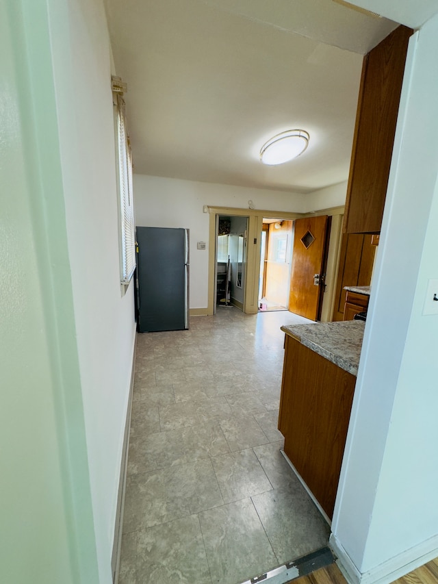 kitchen featuring baseboards, light countertops, and freestanding refrigerator