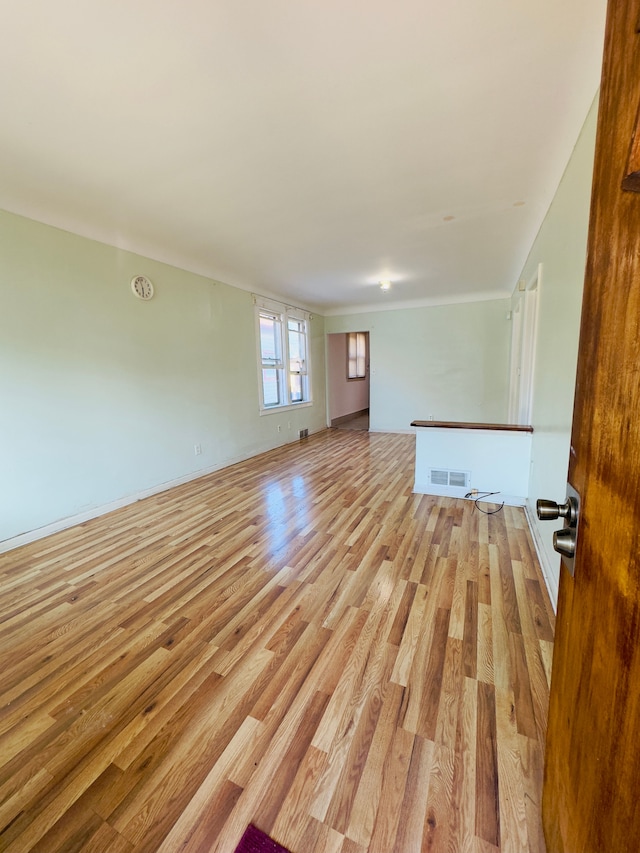 unfurnished living room featuring visible vents and light wood-style flooring