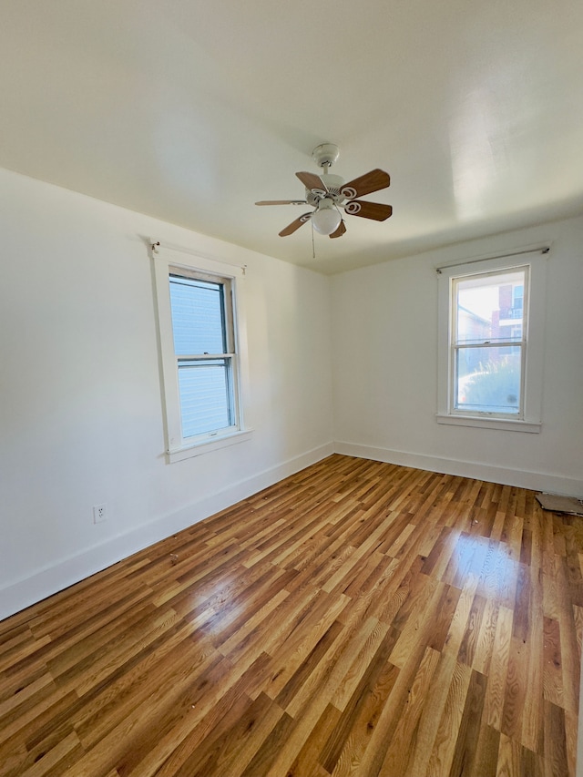 empty room featuring light wood-type flooring, baseboards, and ceiling fan