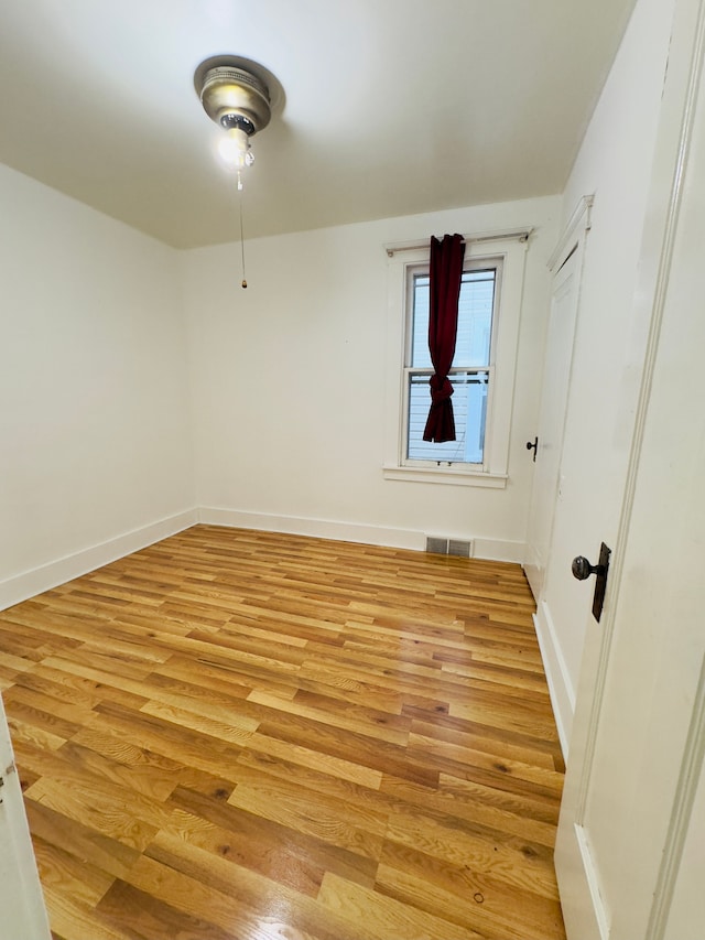 spare room with visible vents, baseboards, and light wood finished floors