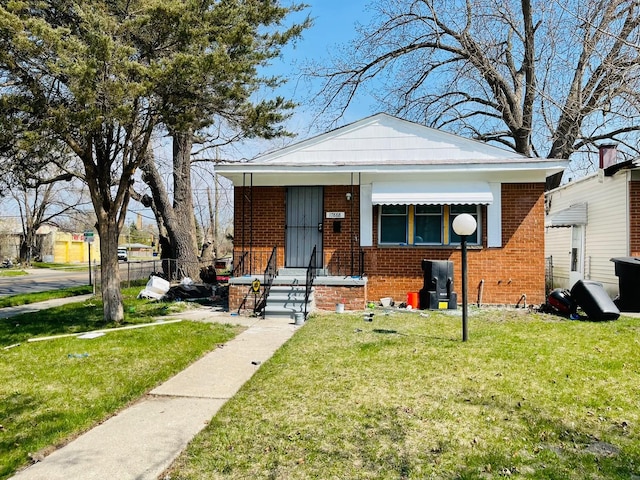 bungalow-style house featuring brick siding, a front yard, and fence