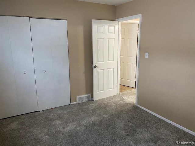 unfurnished bedroom with carpet floors, baseboards, visible vents, and a closet