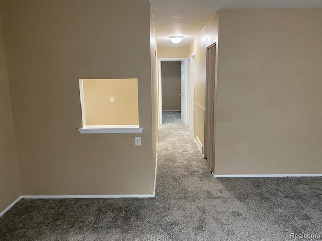 corridor with baseboards and carpet flooring