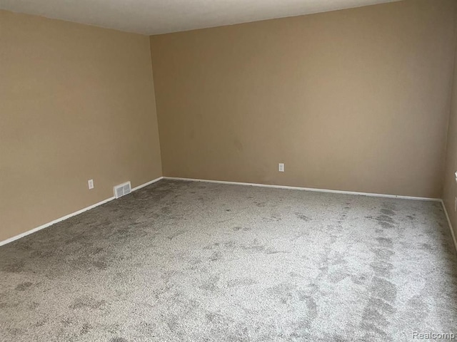 unfurnished room featuring carpet flooring, baseboards, and visible vents
