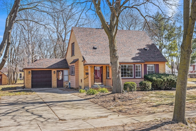 view of front facade with a garage, brick siding, roof with shingles, and concrete driveway