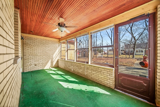 unfurnished sunroom featuring wooden ceiling and a ceiling fan