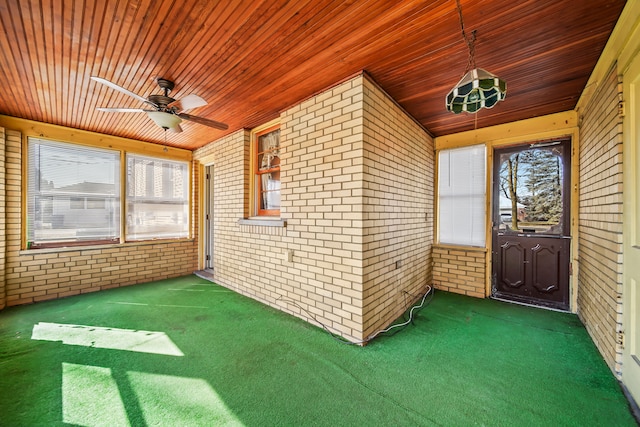 unfurnished sunroom with wooden ceiling and a ceiling fan