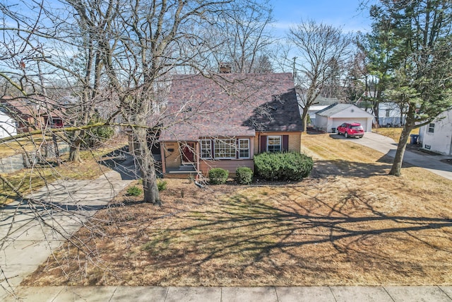 view of front of property featuring brick siding, a chimney, concrete driveway, and a garage