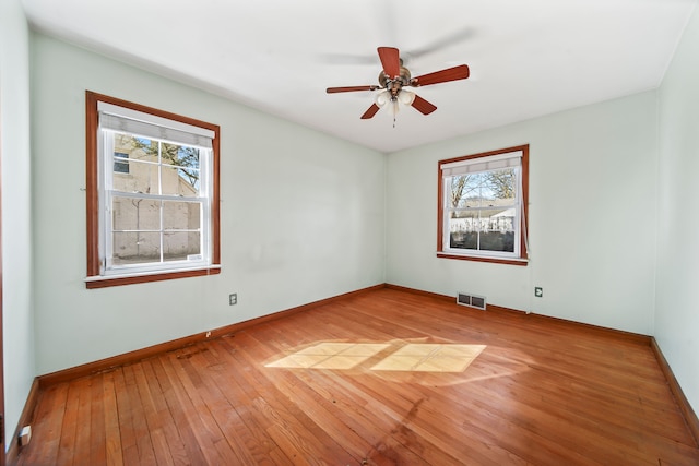 empty room featuring visible vents, ceiling fan, baseboards, and light wood-style floors