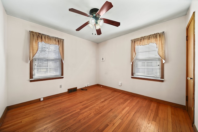 unfurnished room featuring visible vents, wood-type flooring, baseboards, and a ceiling fan