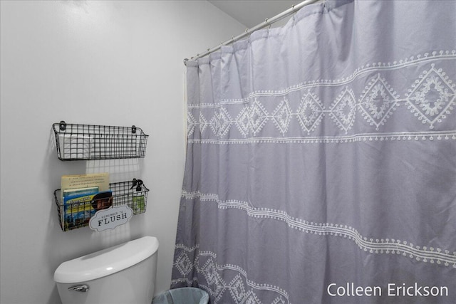 full bathroom featuring a shower with shower curtain and toilet