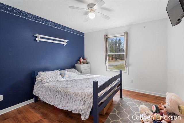 bedroom with baseboards, wood finished floors, and a ceiling fan