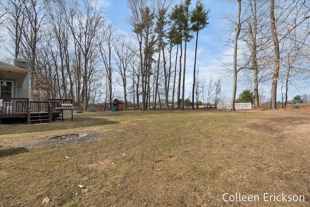 view of yard with a fire pit and a deck