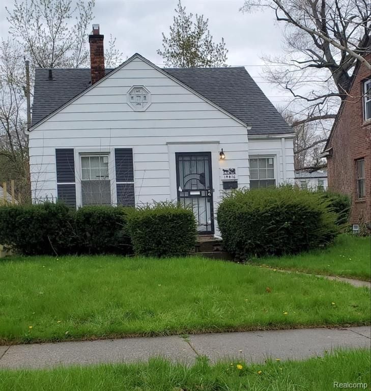 view of front of property with roof with shingles and a chimney