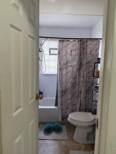 full bathroom featuring toilet and shower / bath combination with curtain