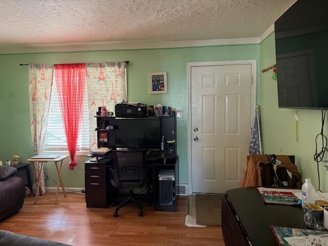 home office with crown molding, wood finished floors, and a textured ceiling