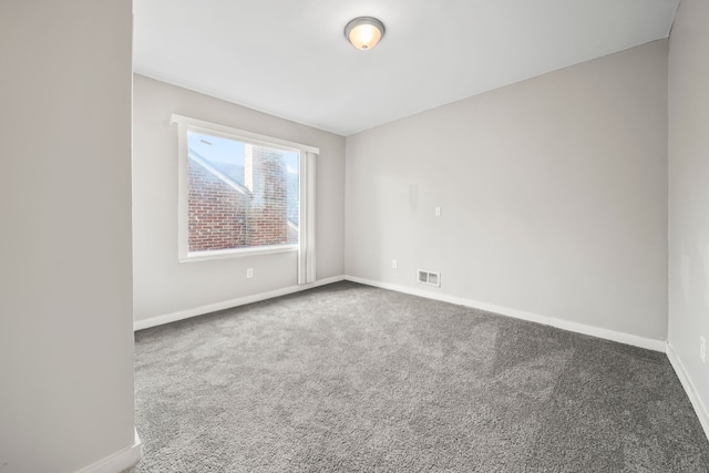 carpeted empty room featuring visible vents and baseboards