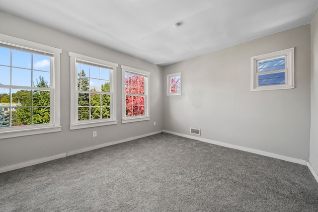 unfurnished room with carpet flooring, baseboards, and visible vents